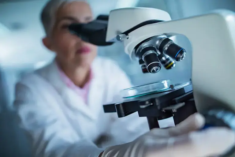 Female scientist looking through microscope