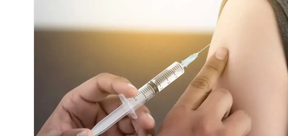 Close-up of an injection being administered into the top of an unseen patient's arm