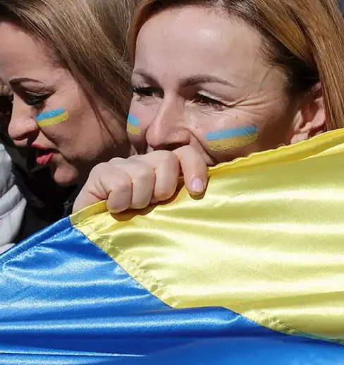 Woman holding a large Ukraine flag close to her face