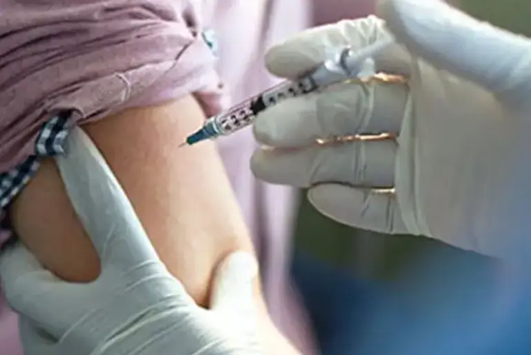 Close up of a health care professional administering an injection in a patient's arm